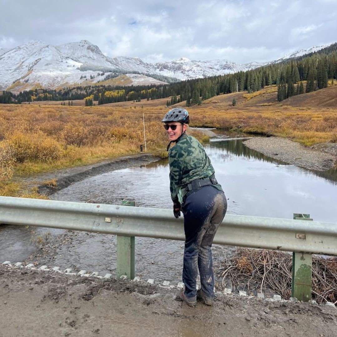 Photo of Emily muddy from mountain biking.