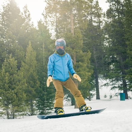 A boy snowboarding down the mountain