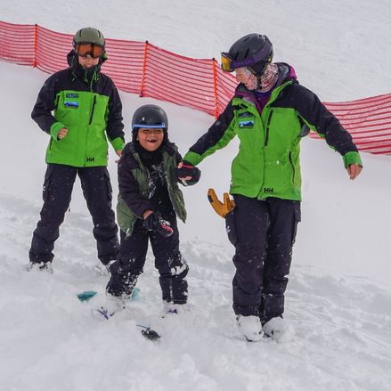 Photo of a child laughing while learning how to ski